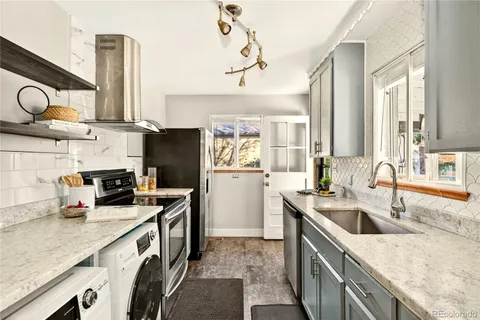 a kitchen with granite countertop a sink a counter top space appliances and cabinets