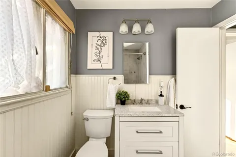 a bathroom with a toilet a sink and a mirror