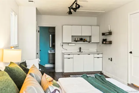 a living room with stainless steel appliances furniture a rug and a window