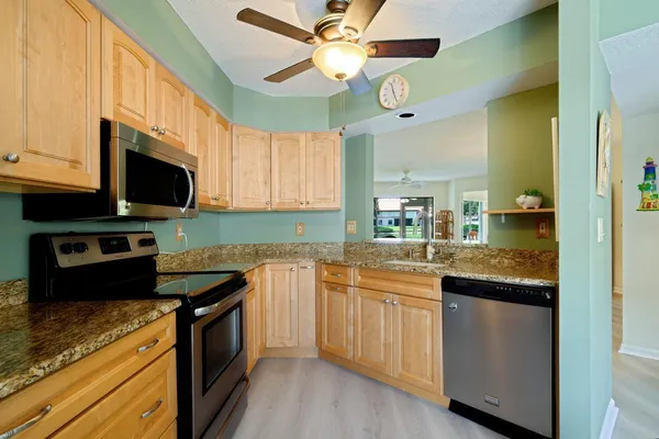a kitchen with stainless steel appliances granite countertop a sink and a stove