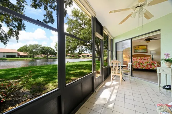 a view of a porch with furniture and a lake view