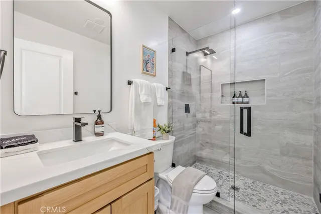 a bathroom with a sink a toilet and shower