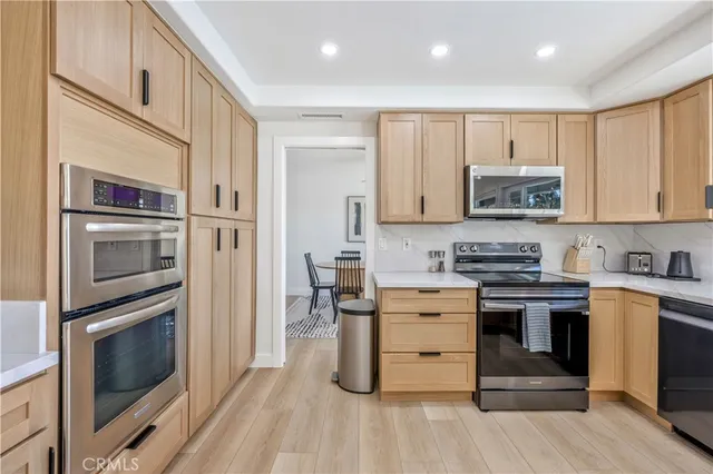a kitchen with stainless steel appliances granite countertop a stove top oven microwave and cabinets