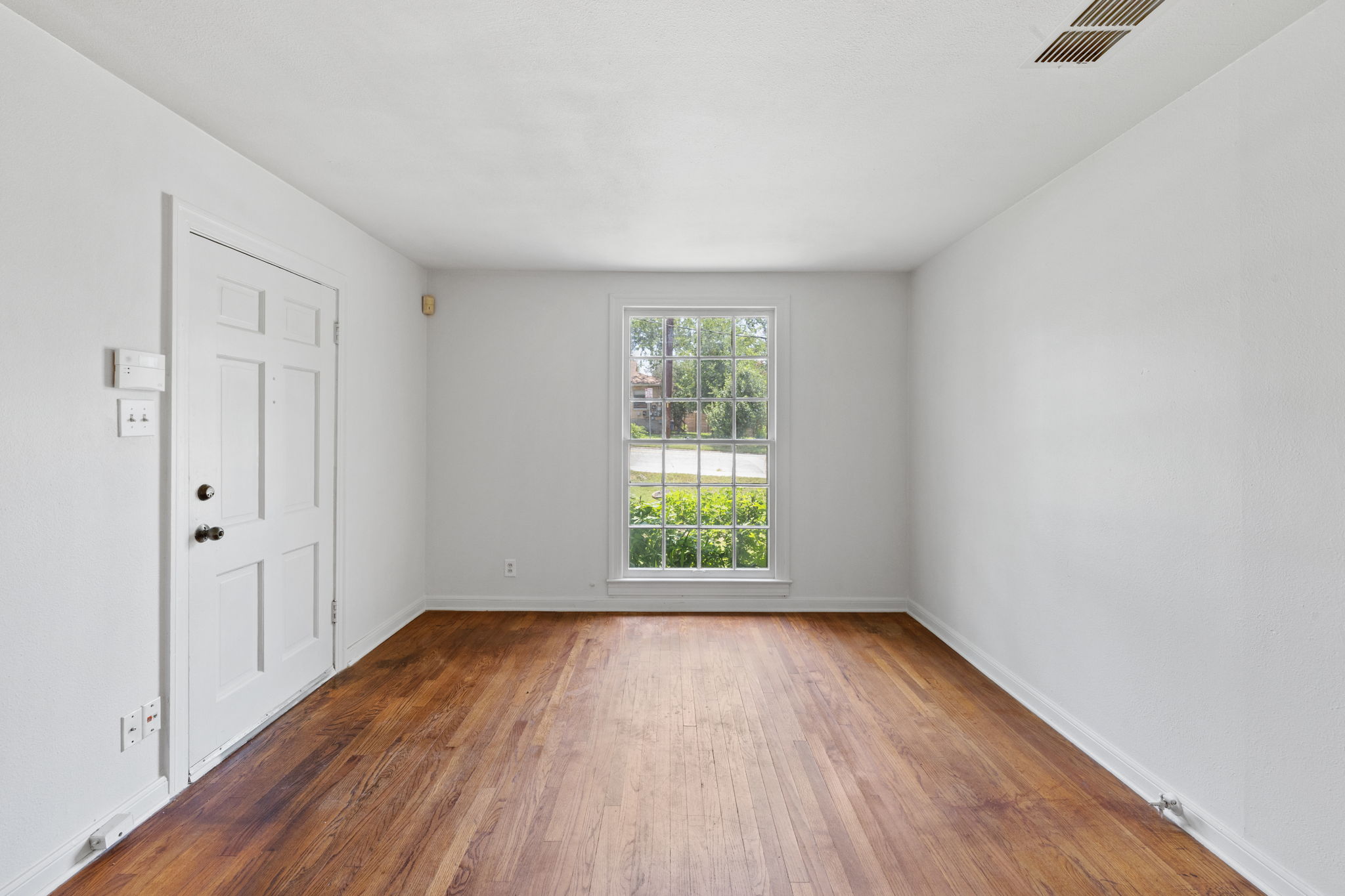 3704 Cherrywood Road Austin, TX 78722 - Photo 7 of 40 An inviting room that features hardwood flooring and a nice window providing natural lighting.