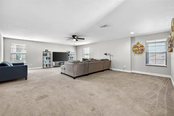 a living room with furniture and ceiling fan