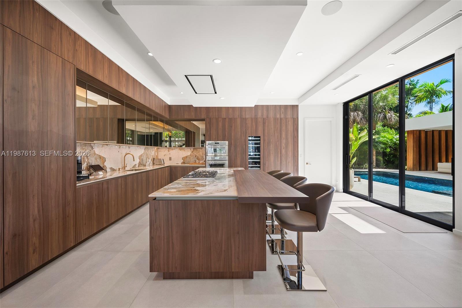 4041 South Le Jeune Road Miami, FL 33133 - Photo 18 of 26 a kitchen with kitchen island stainless steel appliances a sink table and chairs