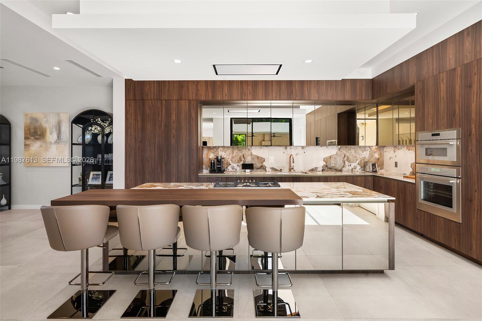 4041 South Le Jeune Road Miami, FL 33133 - Photo 21 of 30 a kitchen with stainless steel appliances granite countertop a table chairs sink and cabinets
