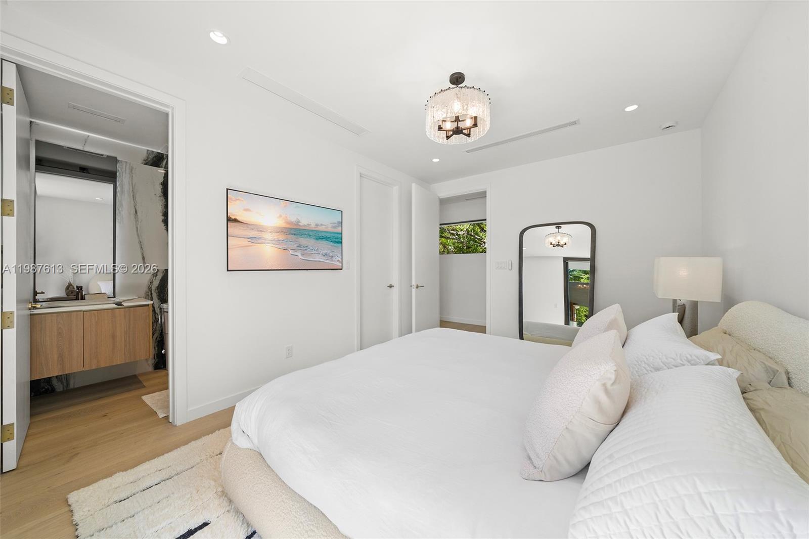 4041 South Le Jeune Road Miami, FL 33133 - Photo 10 of 30 a bedroom with a large bed and a chandelier