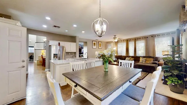 a view of a dining room and livingroom with furniture wooden floor a chandelier