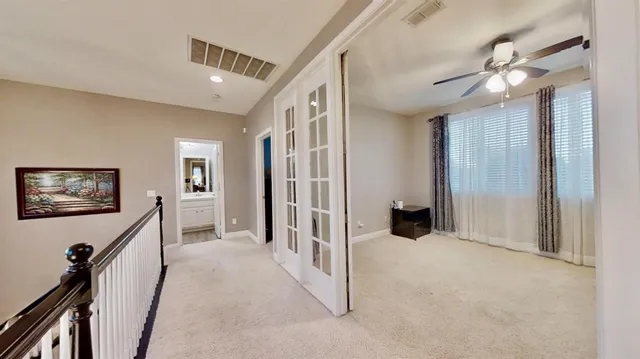 an empty room with windows and fan