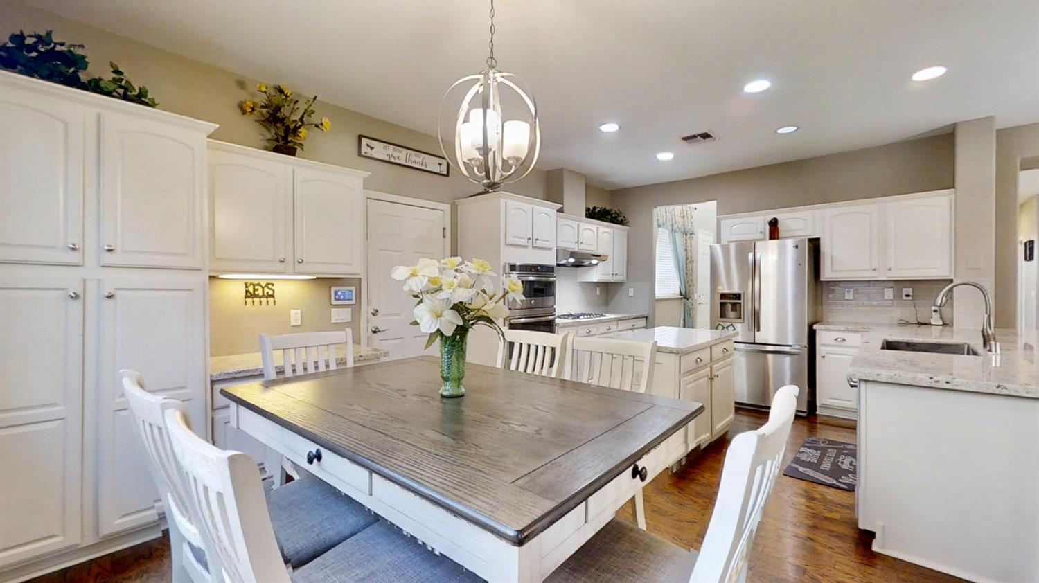 9573 Spring River Way Elk Grove, CA 95624 - Photo 7 of 53 a kitchen with stainless steel appliances a table chairs and refrigerator