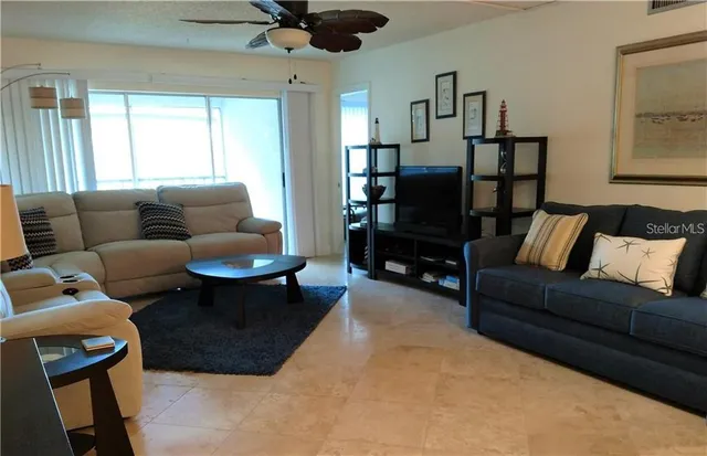 a living room with furniture ceiling fan and a window