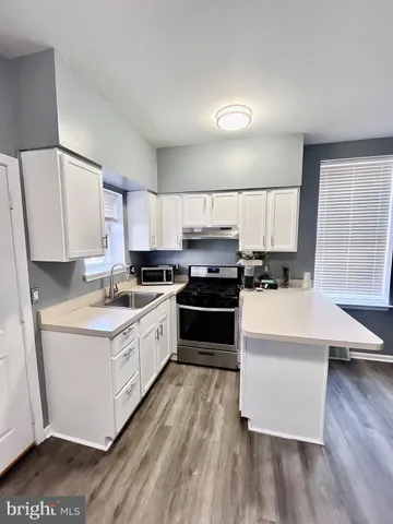 a kitchen with wooden floors and appliances