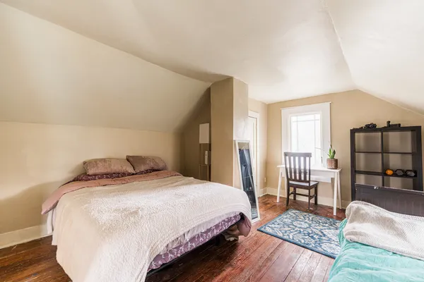 a bedroom with a bed and table chair