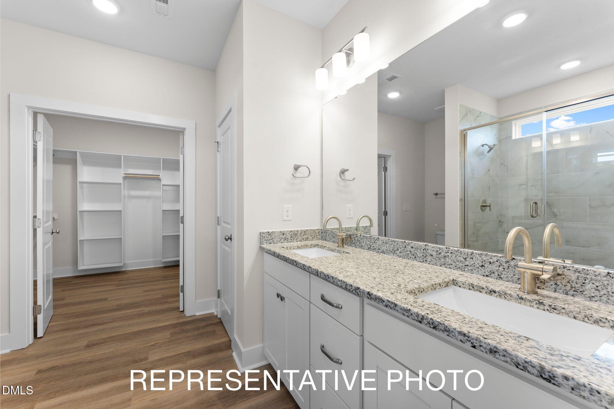 2736 River Meadow Spring Hope, NC 27882 - Photo 6 of 17 a bathroom with a granite countertop sink a mirror and a shower