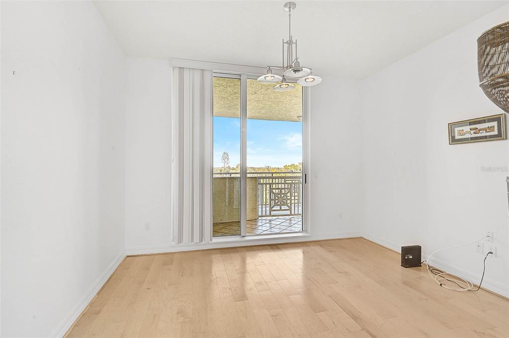 3603 North Point Road, Unit 702 Osprey, FL 34229 - Photo 21 of 61 an empty room with a chandelier fan and windows