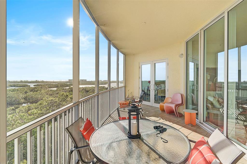 3603 North Point Road, Unit 702 Osprey, FL 34229 - Photo 29 of 61 a balcony with furniture and a floor to ceiling window