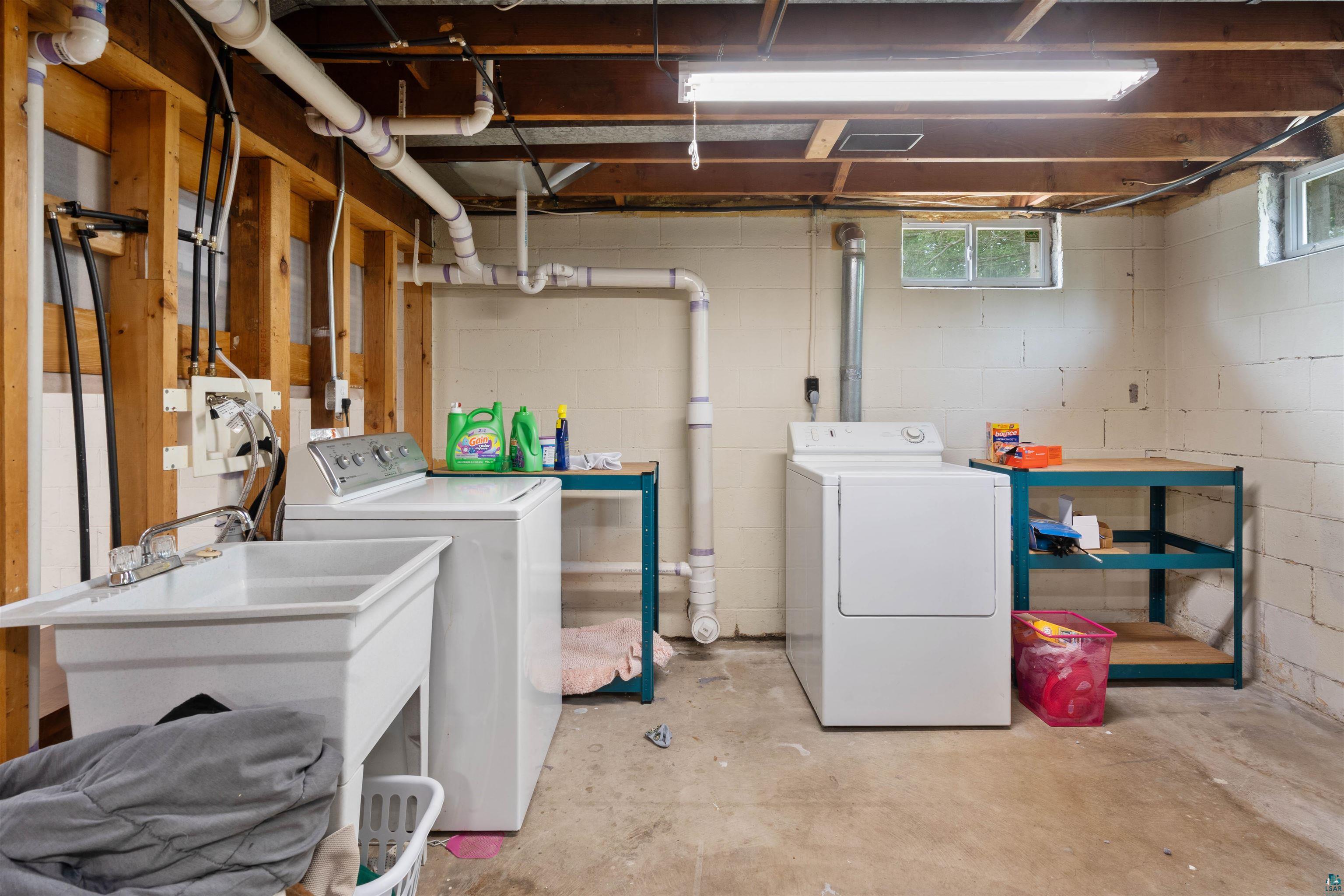 3711 Getchell Road Hermantown, MN 55811 - Photo 19 of 31 Basement utility area featuring a laundry sink with faucet, exposed ceiling joists, and block wall construction