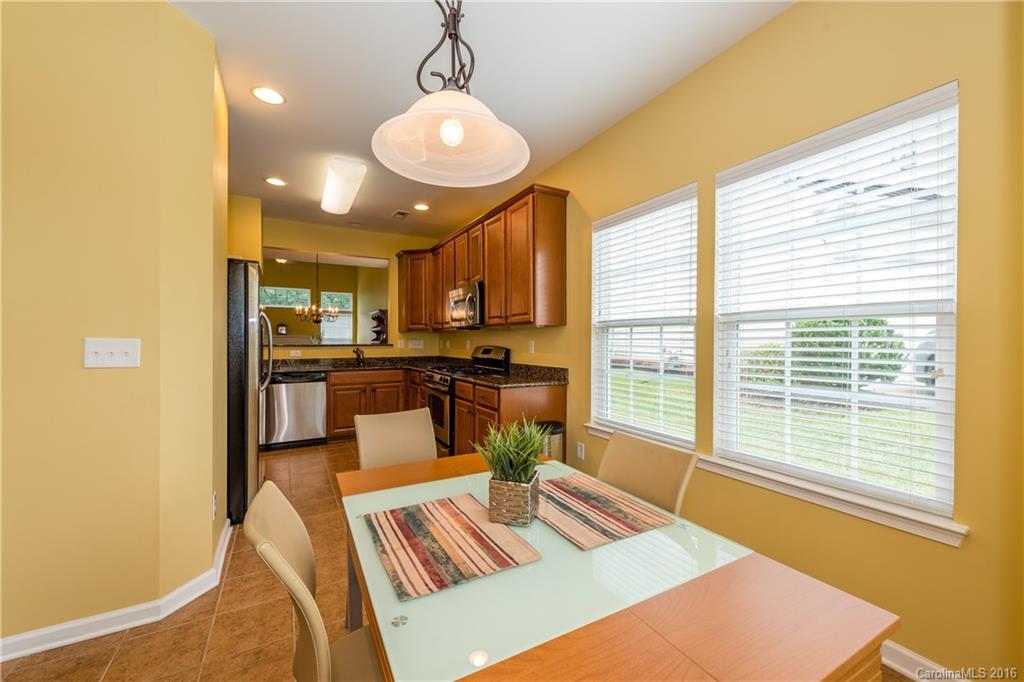 717 Prospect Lane, Unit 46 Fort Mill, SC 29708 - Photo 4 of 19 a view of a dining room with furniture a chandelier and wooden floor