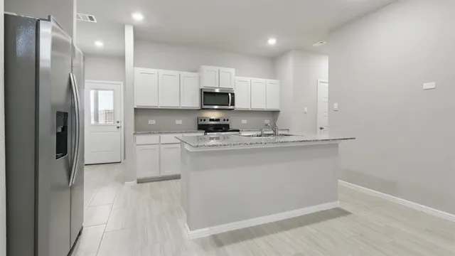 a kitchen with kitchen island white cabinets and stainless steel appliances