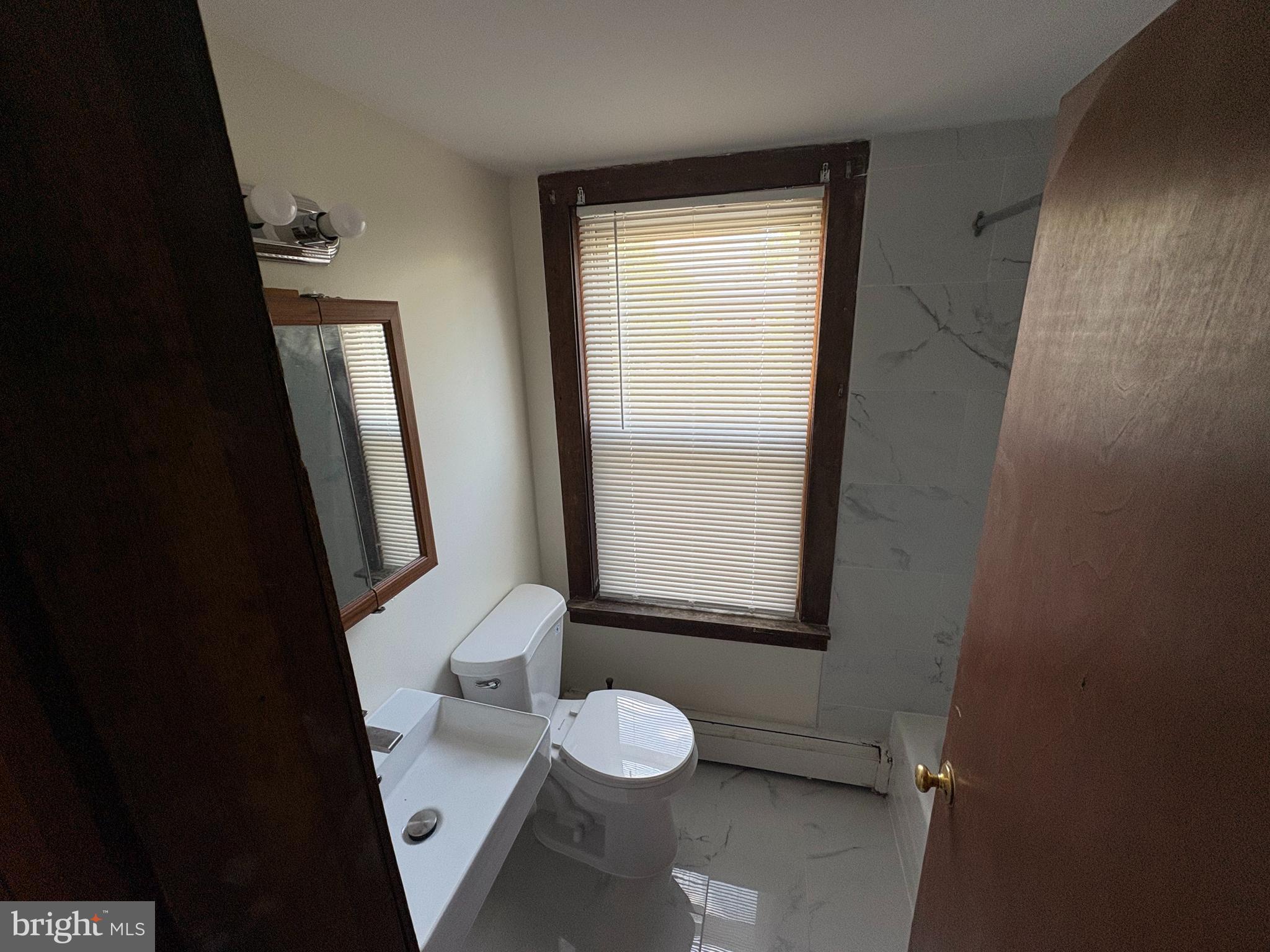 1405 Pennington Road, Unit 2A Ewing, NJ 08618 - Photo 3 of 12 a bathroom with a granite countertop sink toilet and a mirror