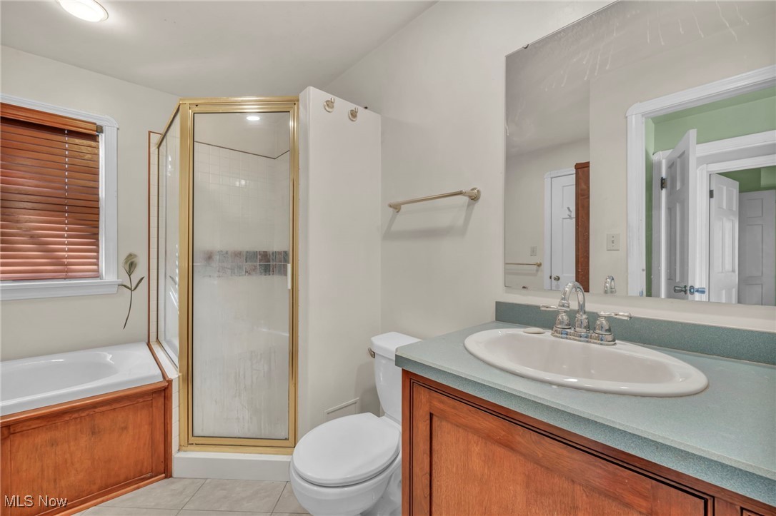 1688 Rushton Road Cleveland, OH 44121 - Photo 26 of 39 Full bathroom featuring toilet, vanity, independent shower and bath, and tile patterned flooring