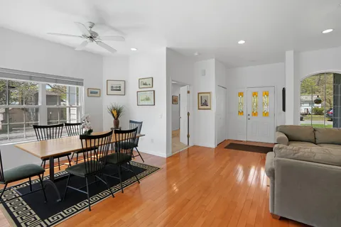 a living room with furniture a rug potted plant and a window