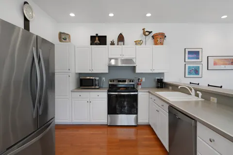 a kitchen with white cabinets and appliances
