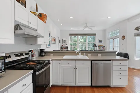 a living room with furniture kitchen view and a large window