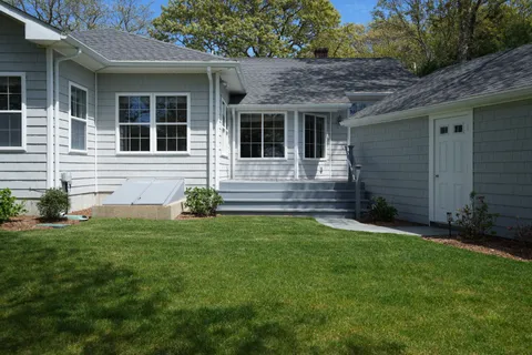 a view of a house with a large window and wooden fence