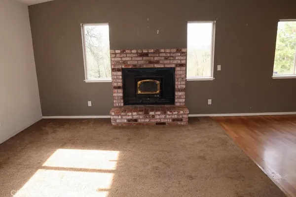 an empty room with kitchen and windows