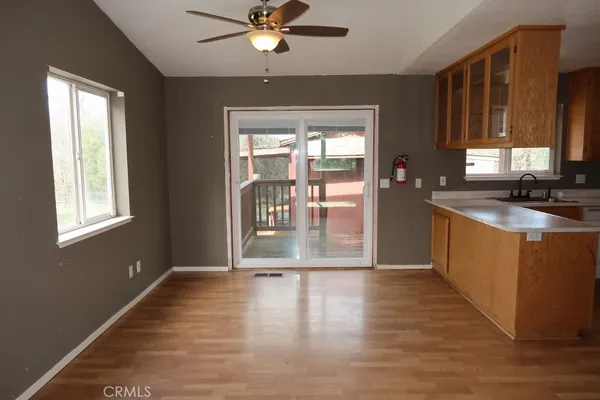 a kitchen with stainless steel appliances granite countertop a refrigerator a stove and a sink with wooden floor