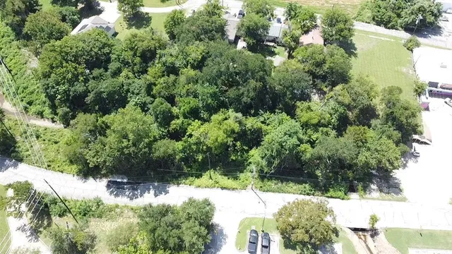 an aerial view of residential house with outdoor space and trees all around
