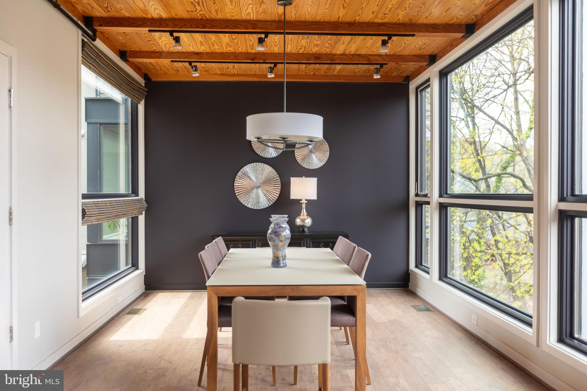 2074 Eric Shaefer Way Baltimore, MD 21211 - Photo 13 of 56 a dining room with wooden floor a glass table and chairs
