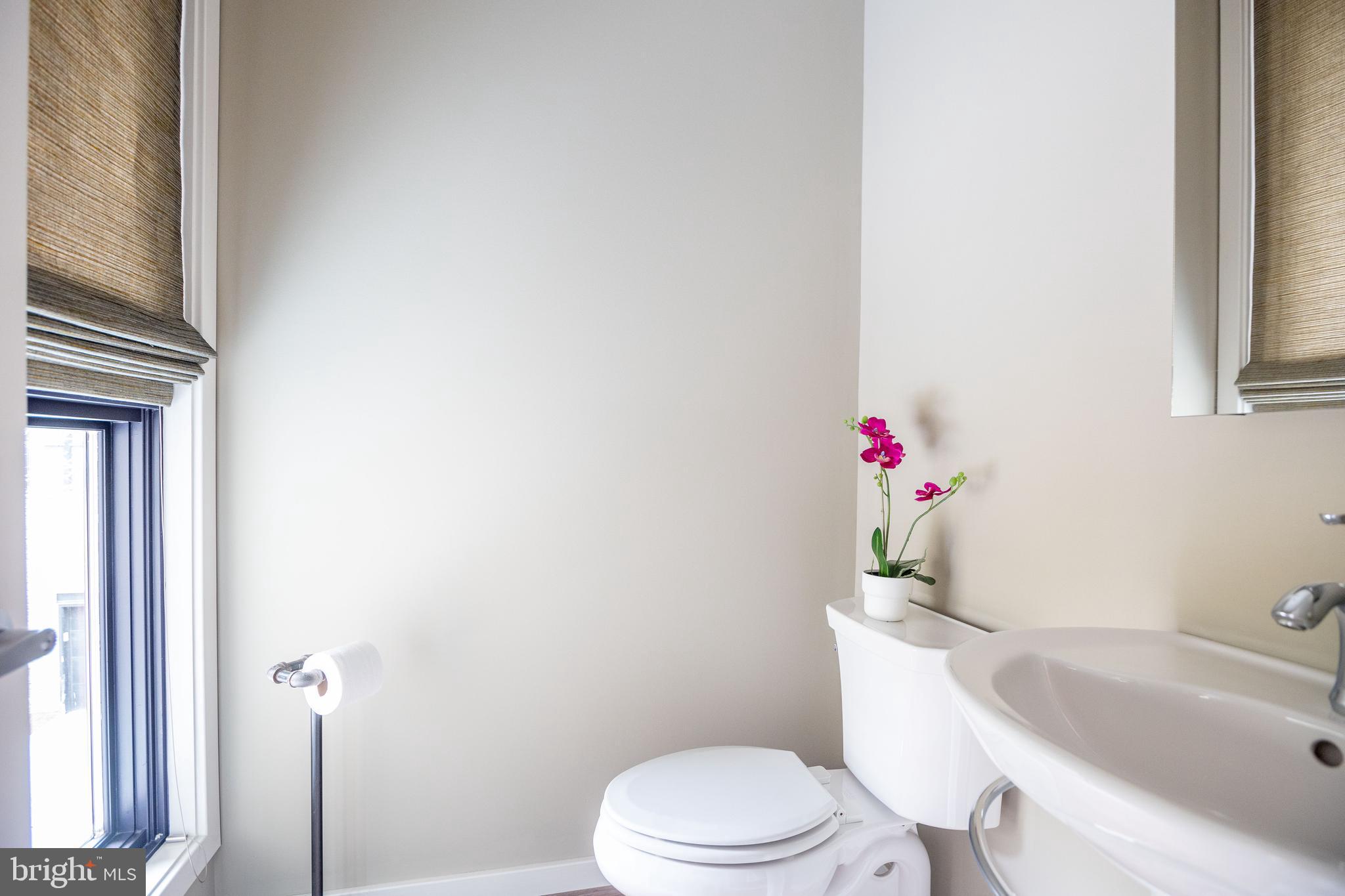 2074 Eric Shaefer Way Baltimore, MD 21211 - Photo 18 of 56 a white toilet sitting next to a bathroom sink