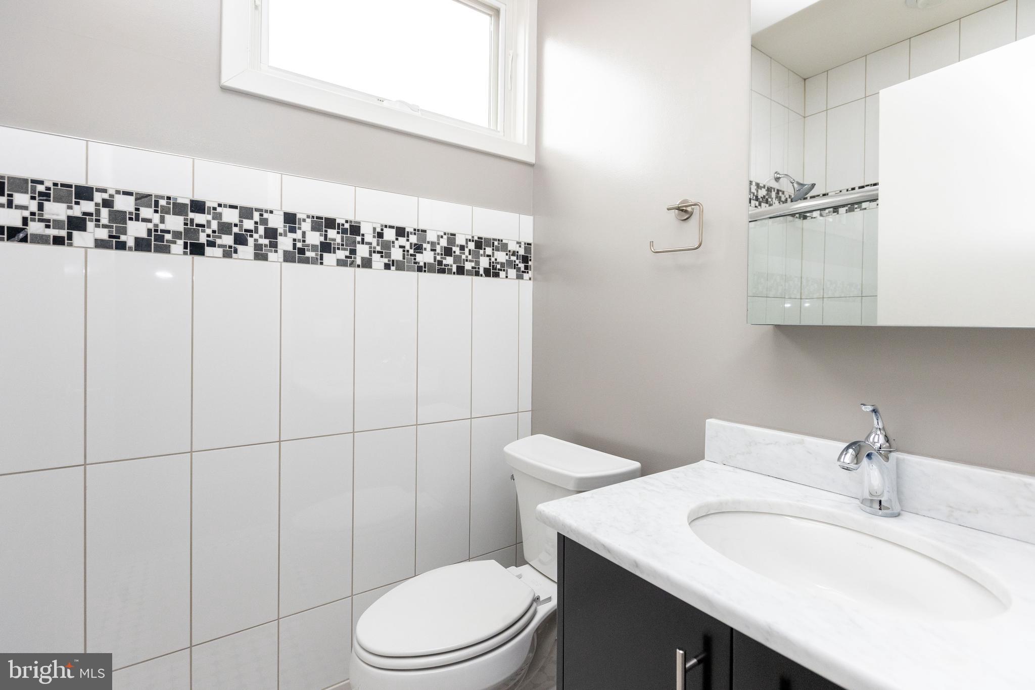 2074 Eric Shaefer Way Baltimore, MD 21211 - Photo 37 of 56 a bathroom with a sink a toilet and shower curtain