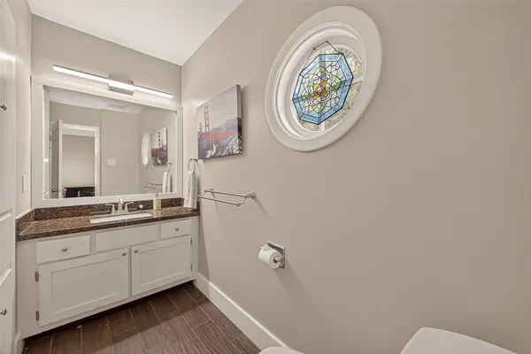 a bathroom with a granite countertop toilet and a sink