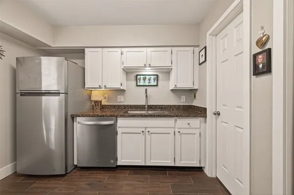 a kitchen with stainless steel appliances granite countertop a refrigerator and a sink