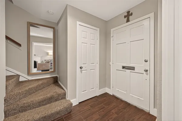 a view of a hallway with wooden floor and closet