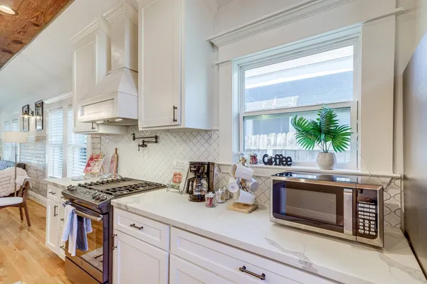 a kitchen with stainless steel appliances granite countertop a stove a sink and a microwave