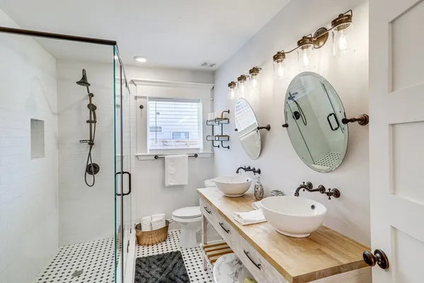 a bathroom with a granite countertop toilet a sink and shower