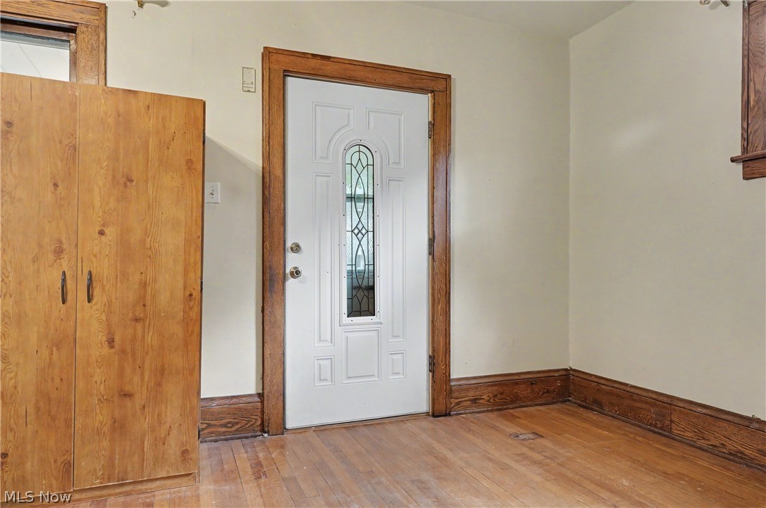 456 Delmar Avenue Akron, OH 44310 - Photo 4 of 27 Entryway featuring a white paneled door with decorative glass inserts, wood-finish flooring, and natural wood trim