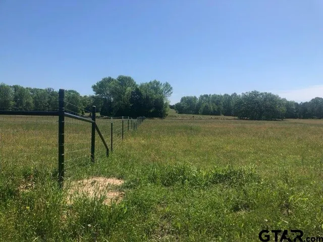 a view of a field with a lake in the background