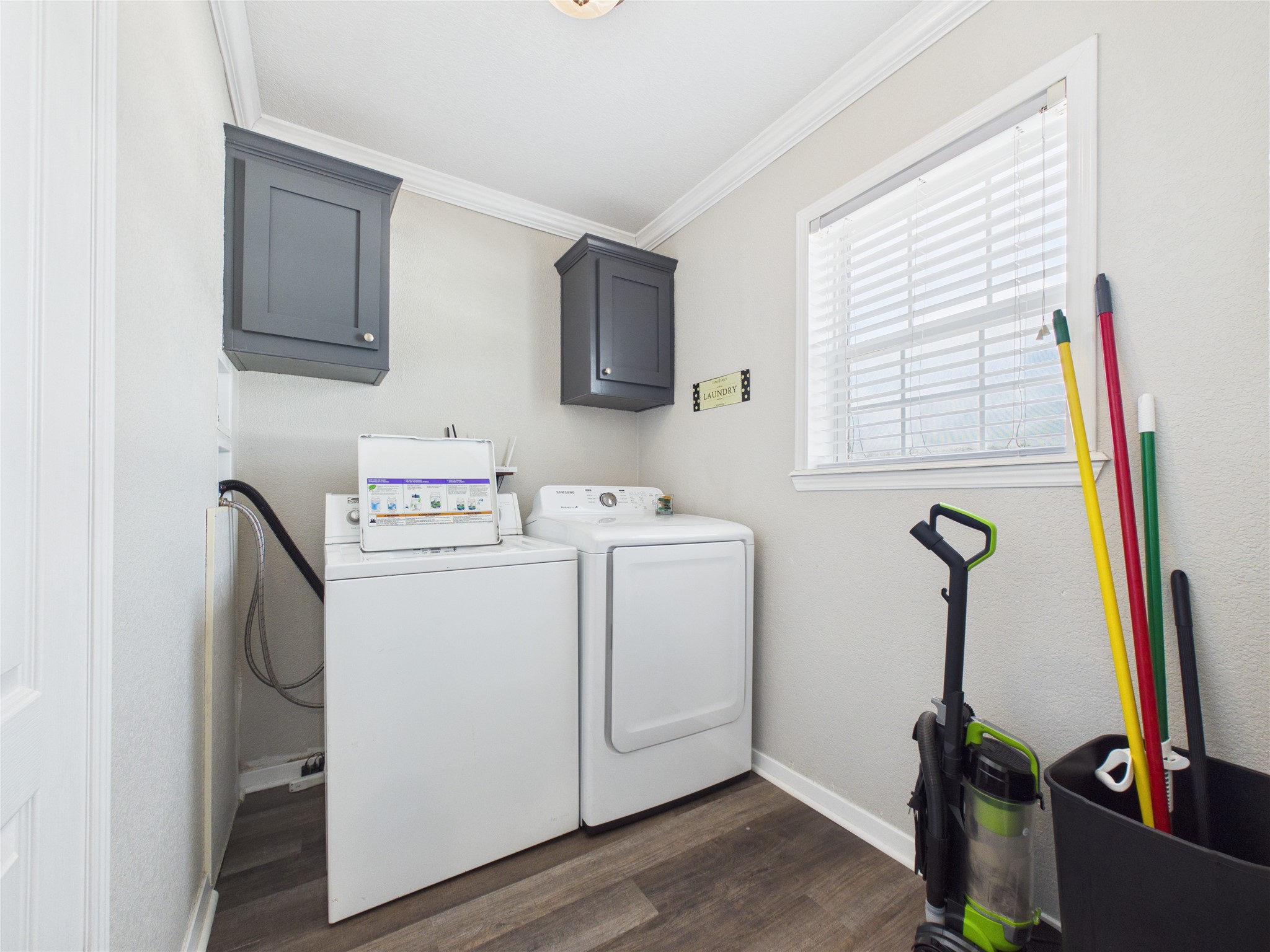 905 Meynig Drive Crystal Beach, TX 77650 - Photo 19 of 50 A dedicated laundry room with a washer and dryer set, dark upper cabinets for storage, and a window for natural light located just off of the dining/kitchen area.