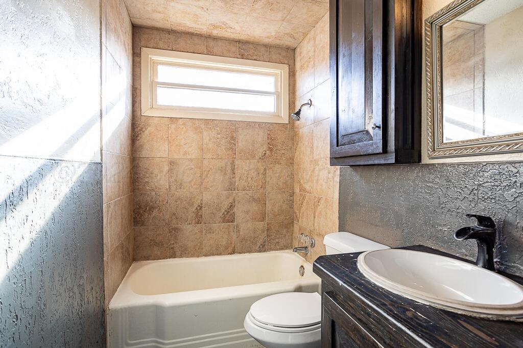 4302 South Jackson Street Amarillo, TX 79110 - Photo 12 of 16 a bathroom with a sink a toilet and bathtub