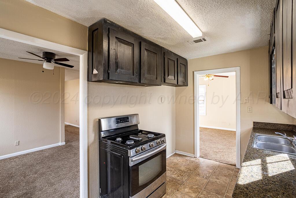 4302 South Jackson Street Amarillo, TX 79110 - Photo 7 of 16 a kitchen with a stove and a refrigerator