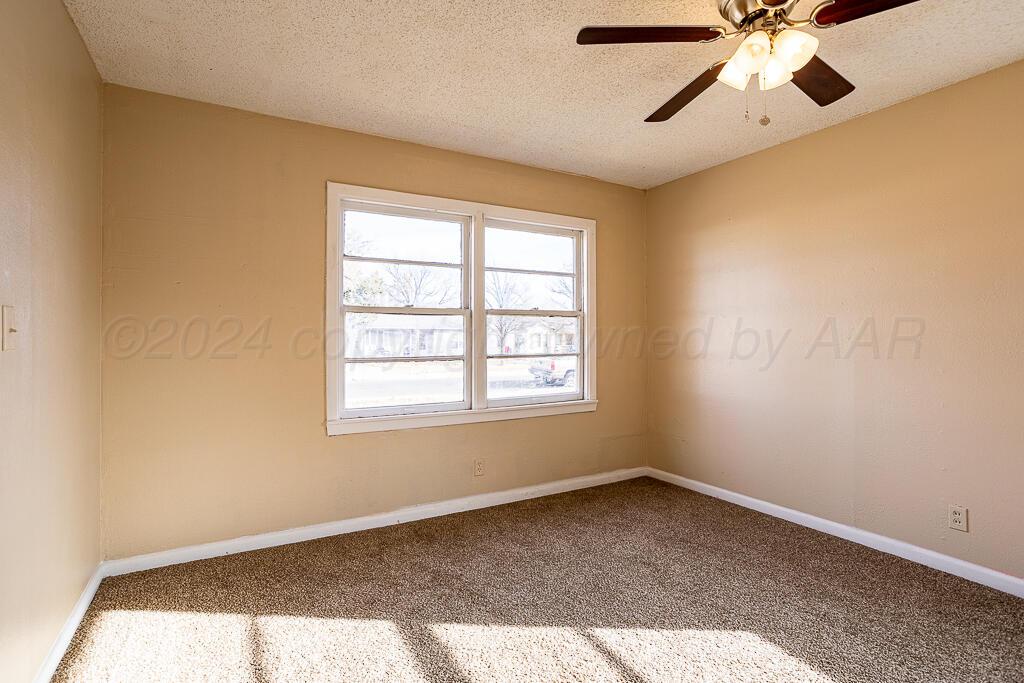 4302 South Jackson Street Amarillo, TX 79110 - Photo 10 of 16 a big room with windows and chandelier fan