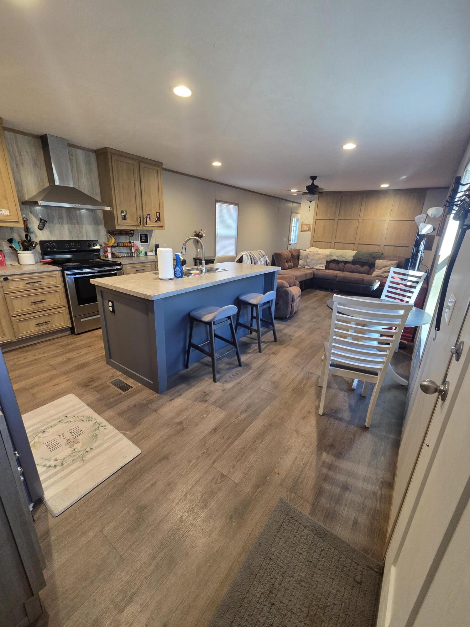 625 Jamestown Road Rocky Mount, VA 24151 - Photo 3 of 11 a kitchen with stainless steel appliances kitchen island granite countertop a refrigerator a stove a sink a dining table and chairs with wooden floor