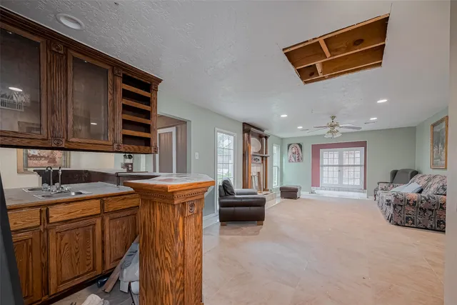 a living room with stainless steel appliances granite countertop furniture a sink and a window