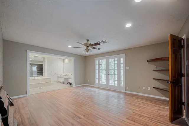 an empty room with windows and cabinet